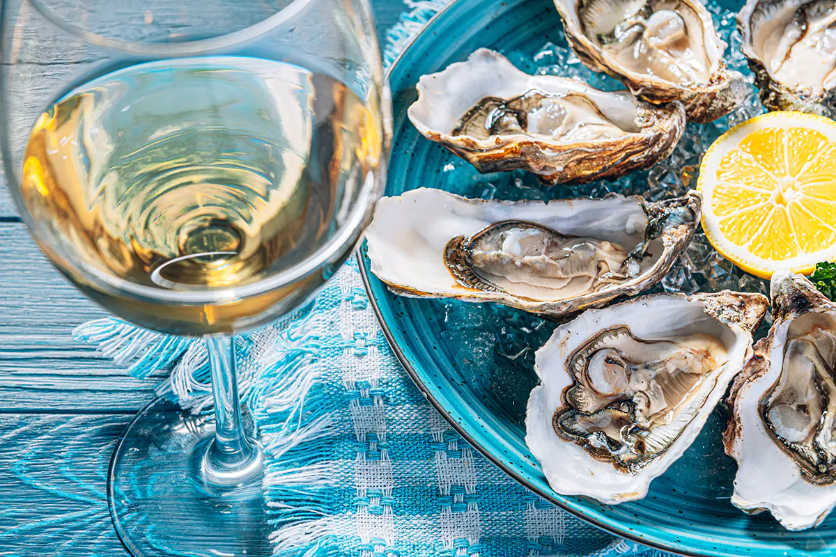 Fresh raw oysters on ice paired with a glass of white wine at Crab 99, a Cajun Seafood & Grill Restaurant in Phoenix